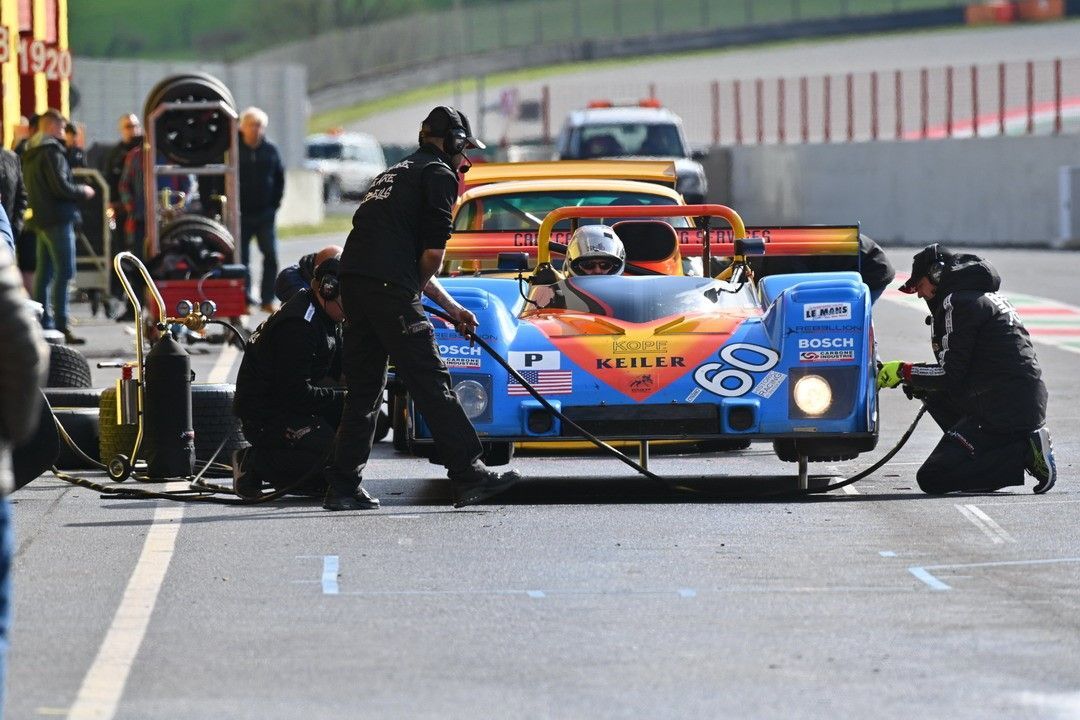 Des mécaniciens en train de réparer une voiture sur un circuit de course