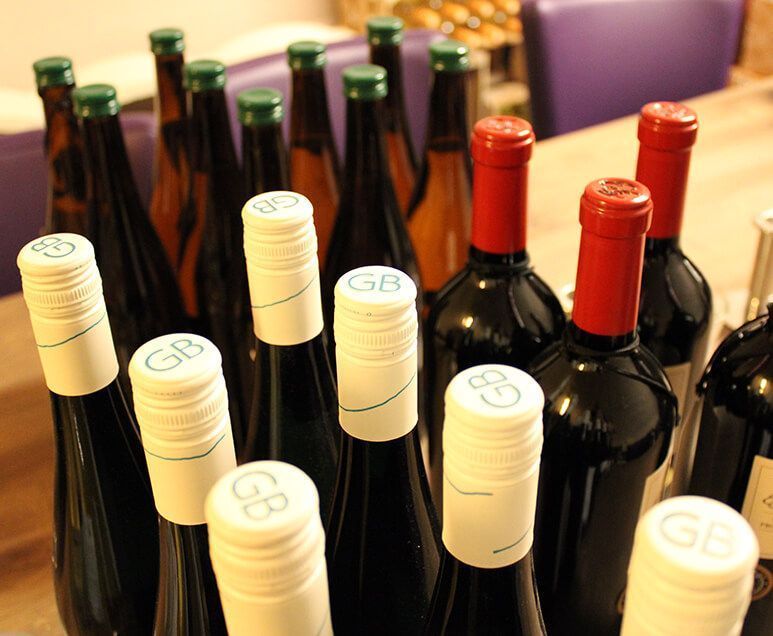 Ein paar Weinflaschen mit weißen Deckeln, auf denen gb steht