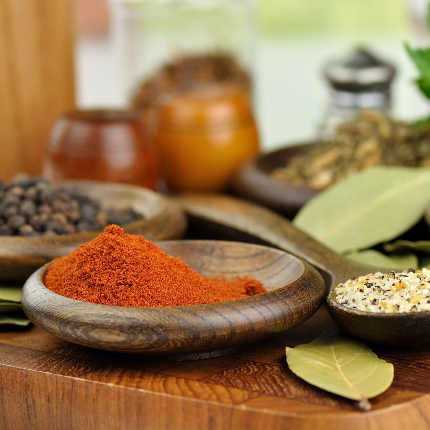 Eine Holzschale gefüllt mit rotem Pfeffer und anderen Gewürzen