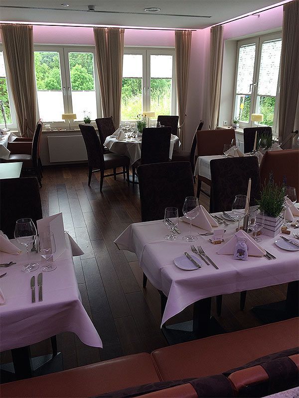 Ein Restaurant mit für eine Mahlzeit gedeckten Tischen und Stühlen.