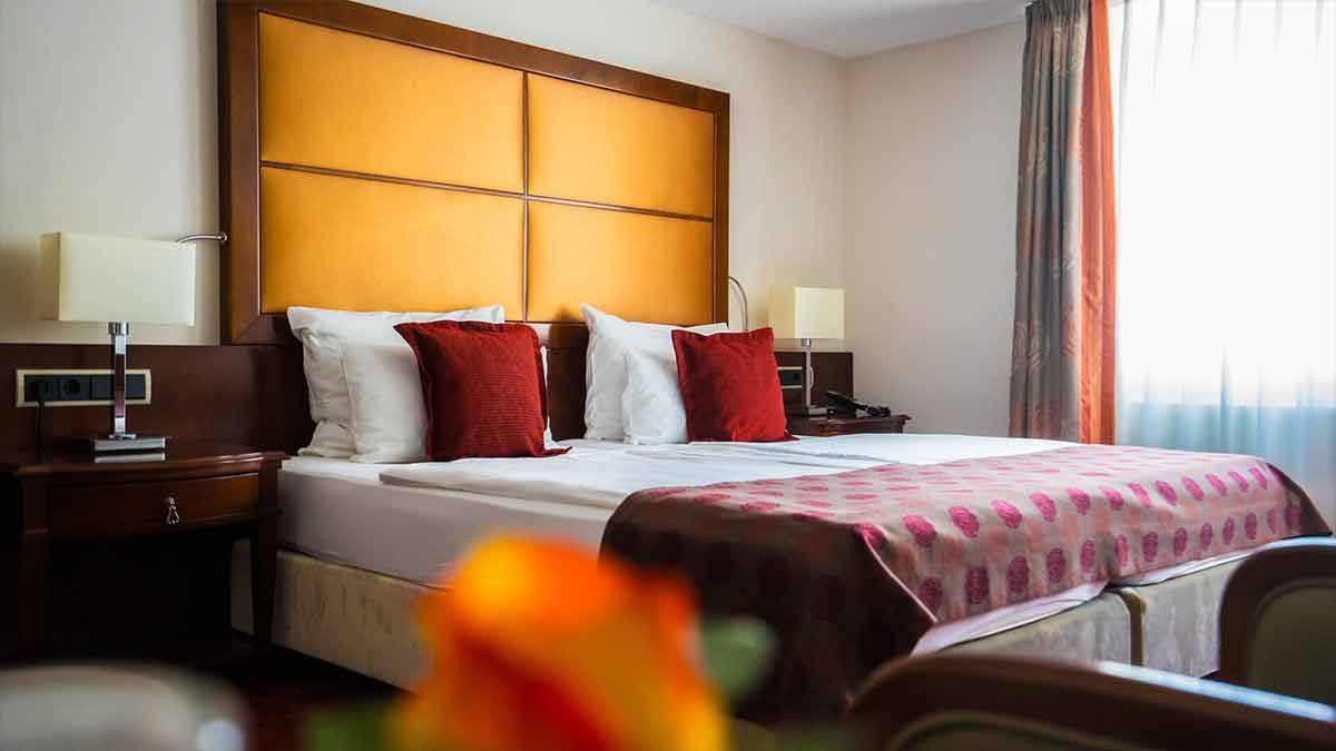 Ein Hotelzimmer mit einem Kingsize-Bett und roten Kissen.