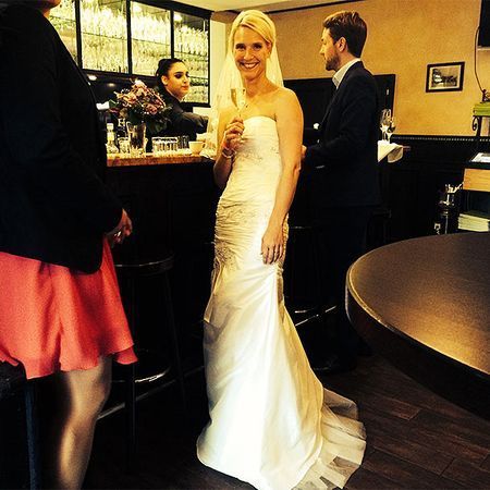 Eine Frau in einem Brautkleid hält ein Glas Champagner