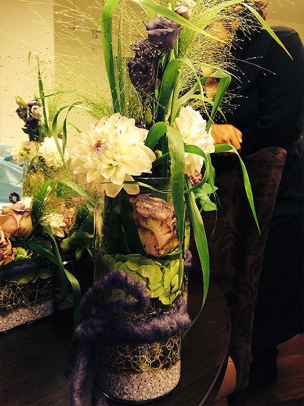 Eine Person, die neben einer Blumenvase auf einem Tisch steht