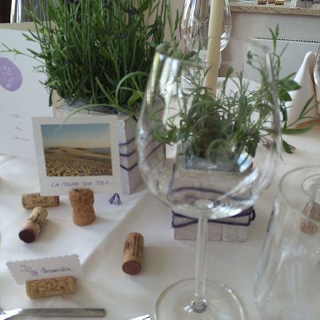 Ein Weinglas mit einer Pflanze darin steht auf einem Tisch