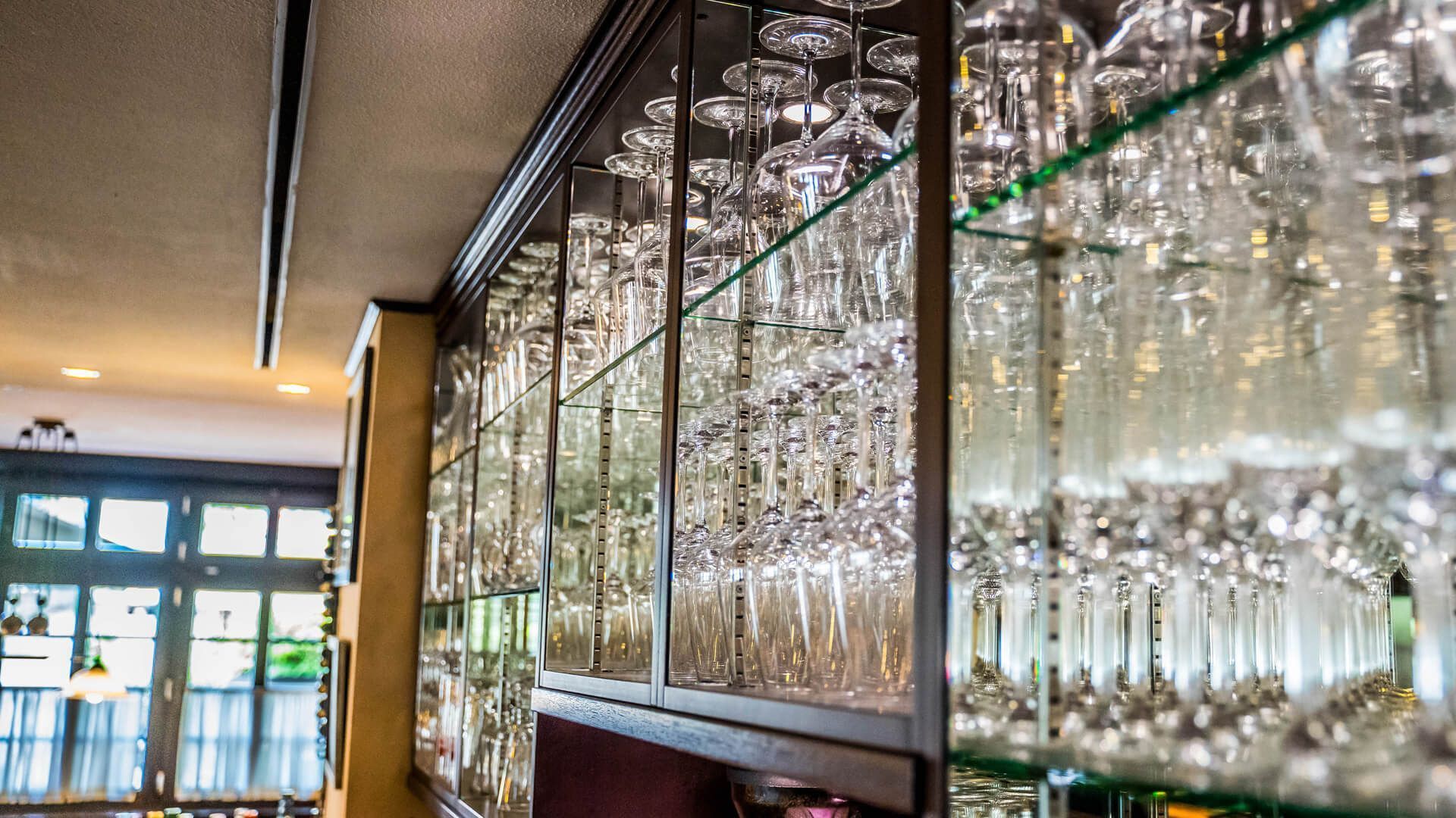 Eine Bar mit vielen Weingläsern in den Regalen.