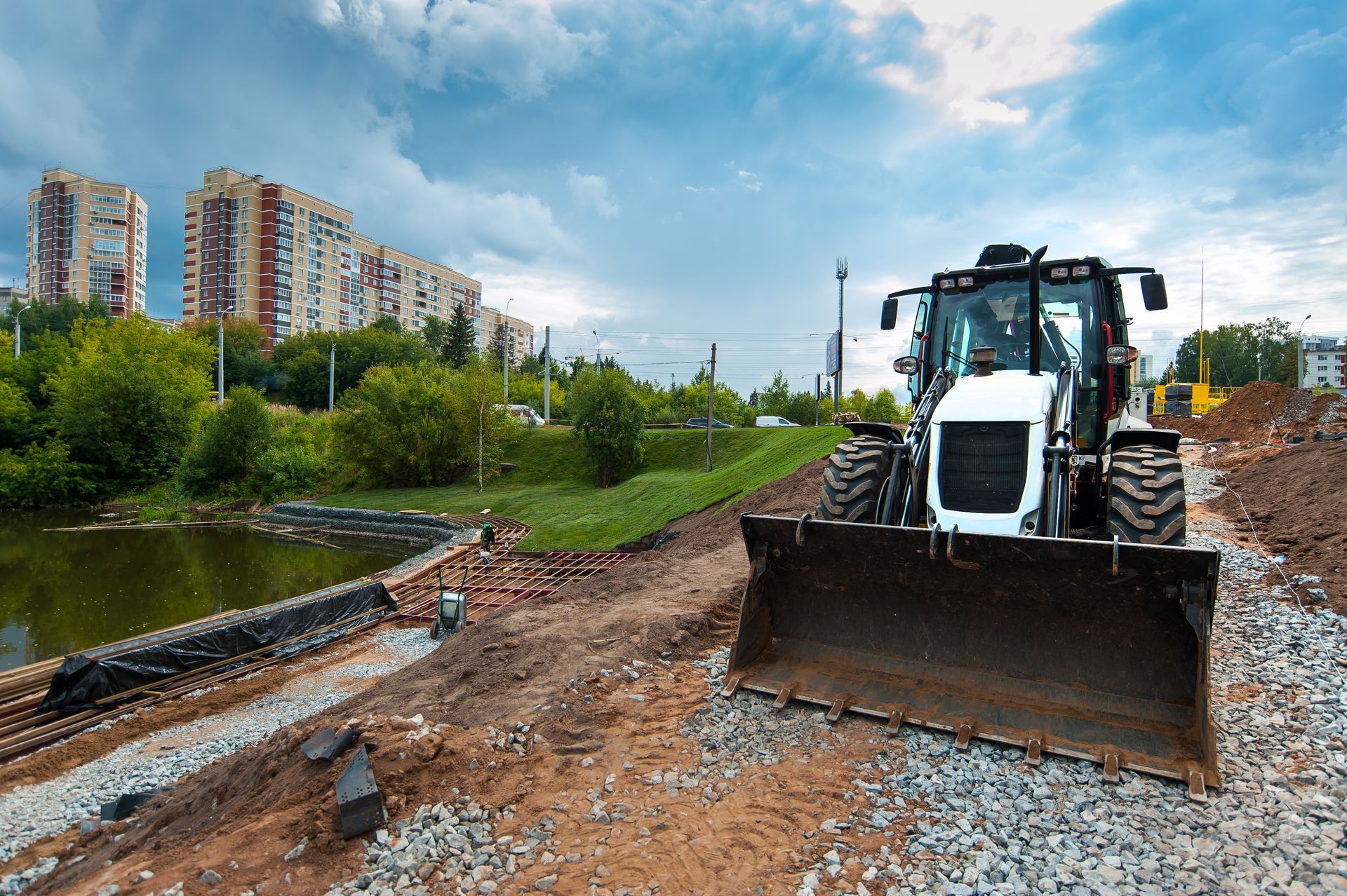 Le tracteur nivelle le sol sur le chantier de construction en été