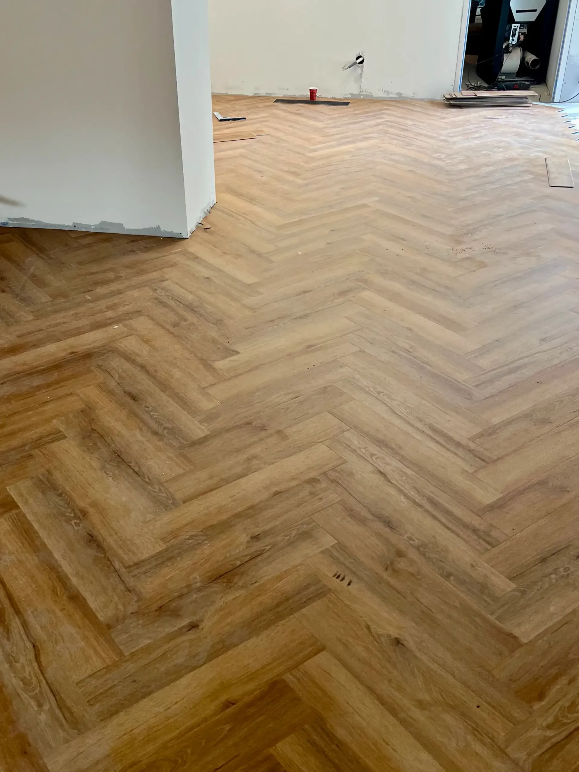 Parquet à chevrons dans une pièce en construction.