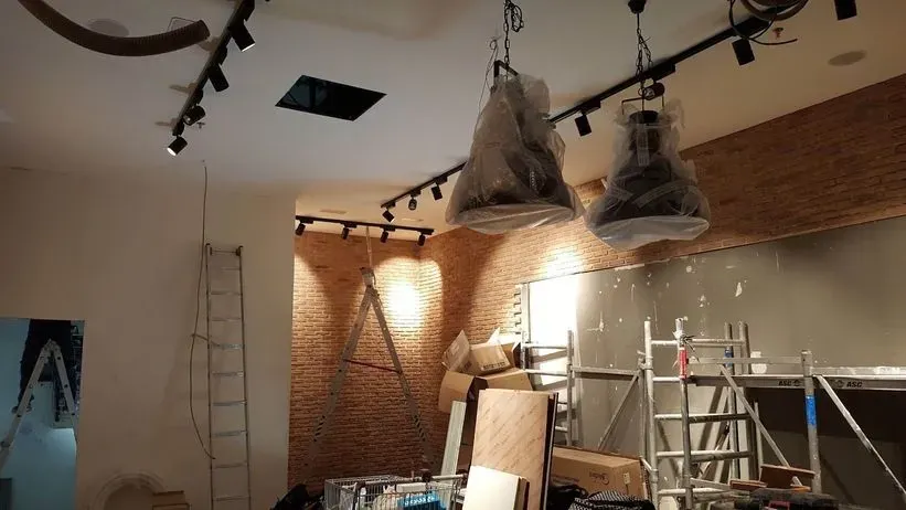 Una habitación que está siendo remodelada con muchas luces colgando del techo.