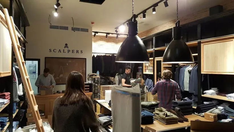 Una mujer está parada en una tienda con un cartel que dice revendedores.