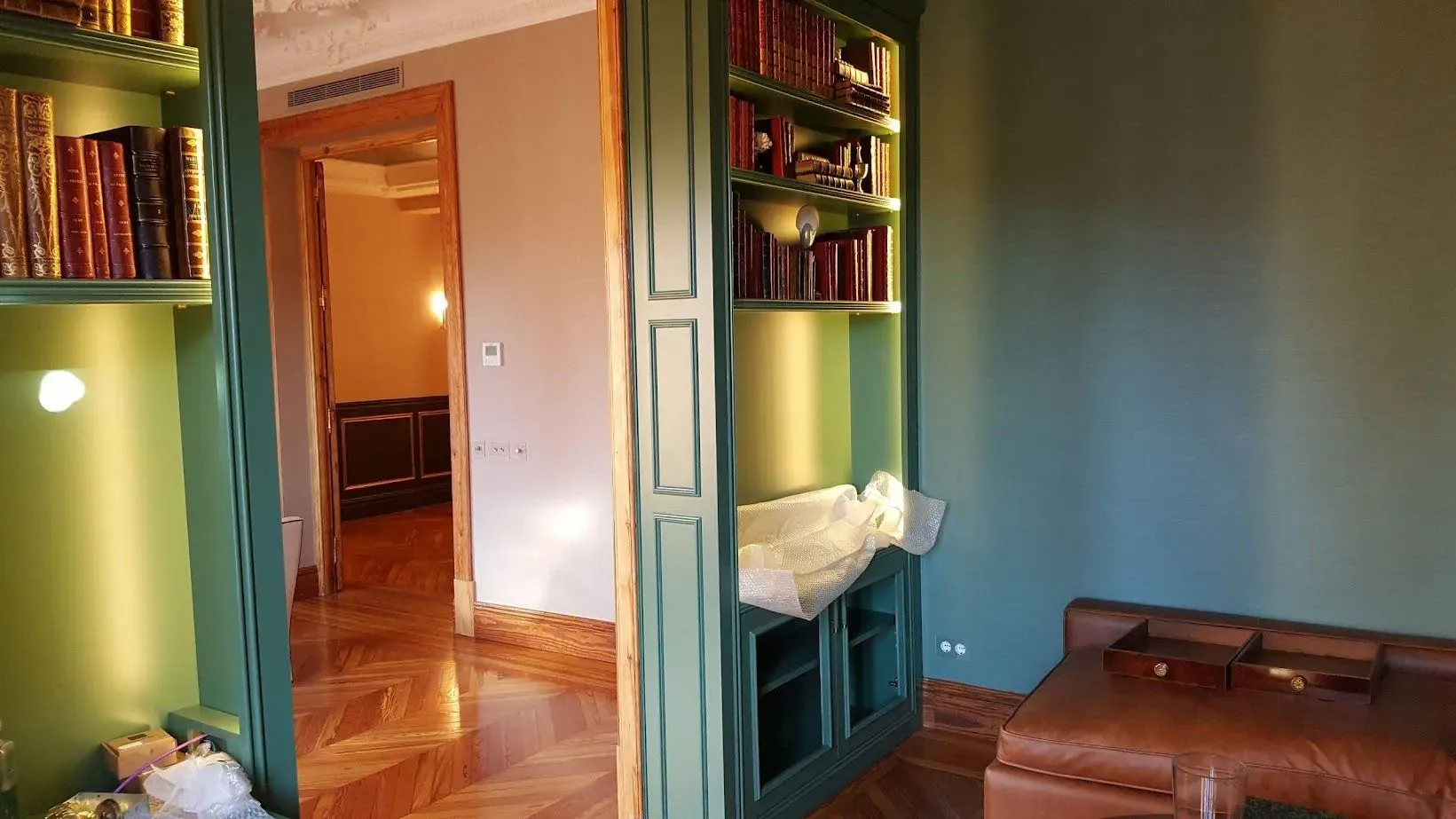 Una sala de estar con un sofá y una estantería llena de libros.