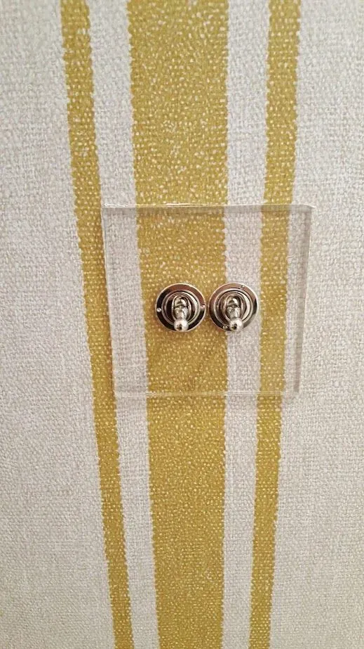 Un par de pendientes se encuentran sobre una vitrina transparente.