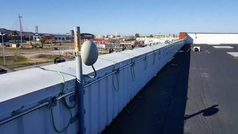 Una antena parabólica está montada en el lateral de un edificio.