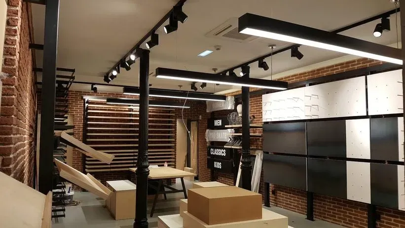 Una habitación grande con muchas luces en el techo y paredes de ladrillo.