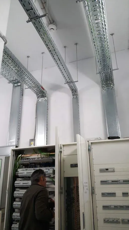 Un hombre está trabajando en una caja eléctrica en una habitación.