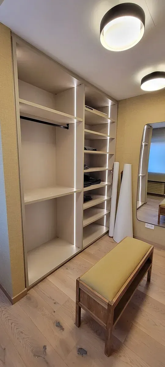 Un vestidor con un banco y un espejo.