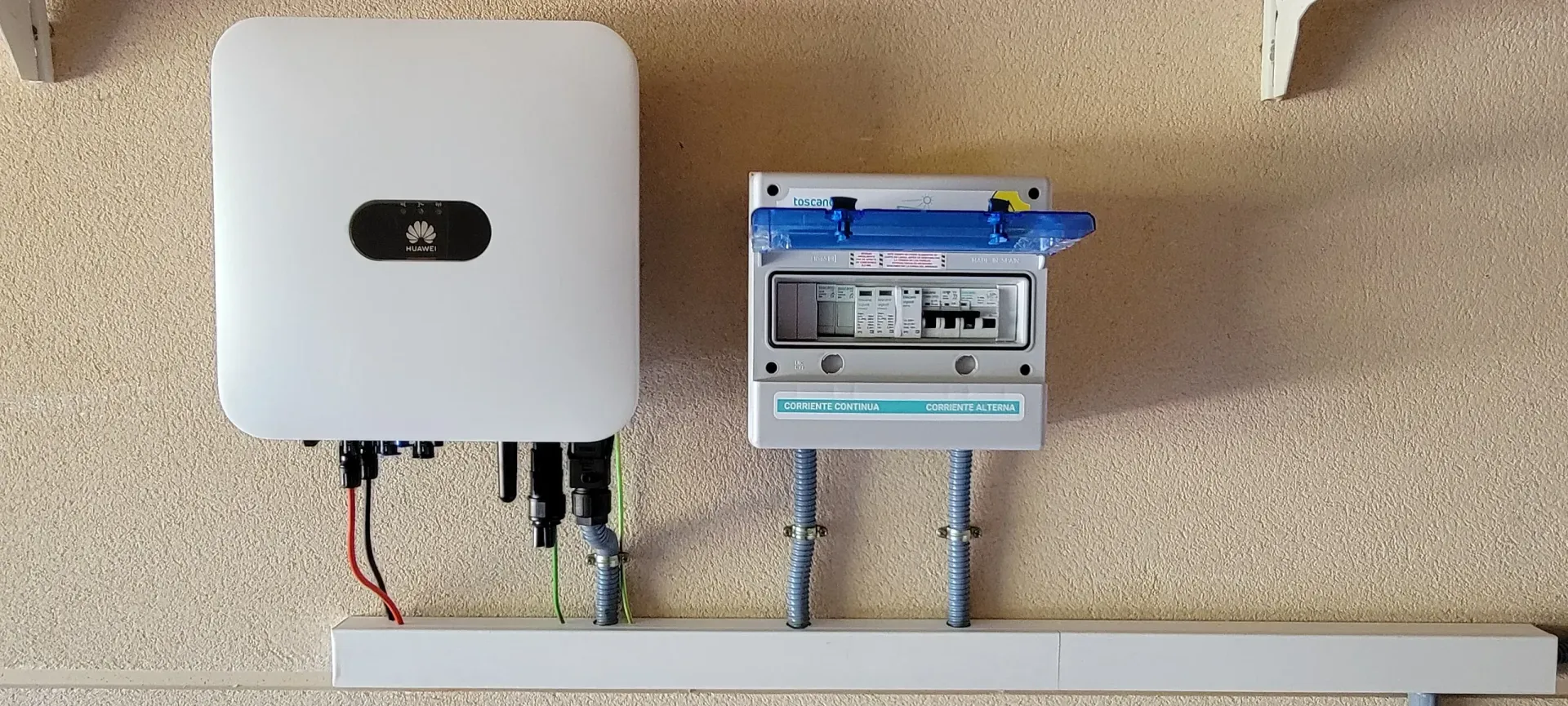 Un panel solar está montado en una pared al lado de una caja.