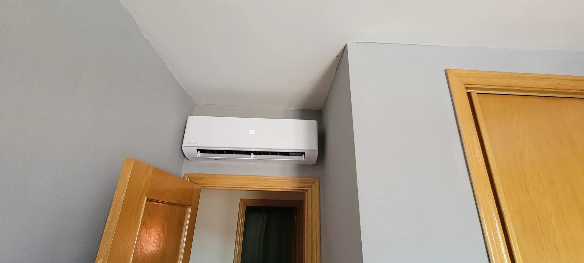 Una habitación con una puerta y un aire acondicionado montado en la pared.