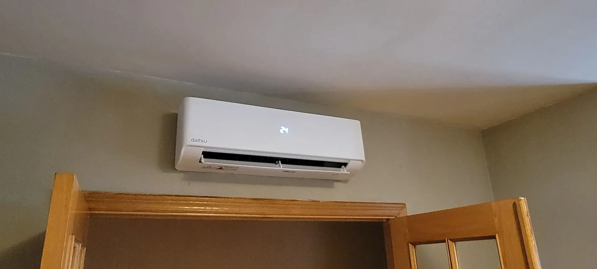 Un acondicionador de aire blanco cuelga del techo de una habitación.