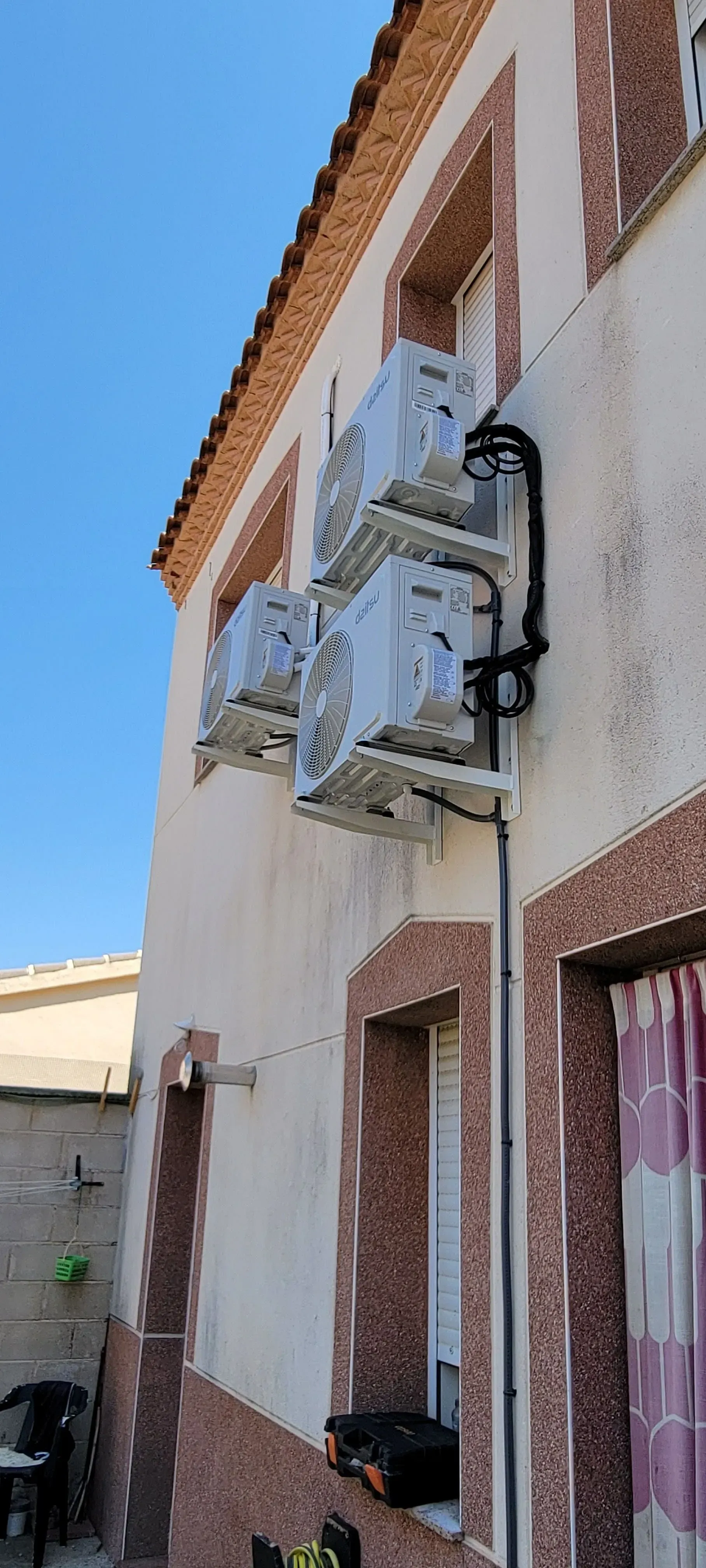 Un edificio con muchos aparatos de aire acondicionado en el costado.
