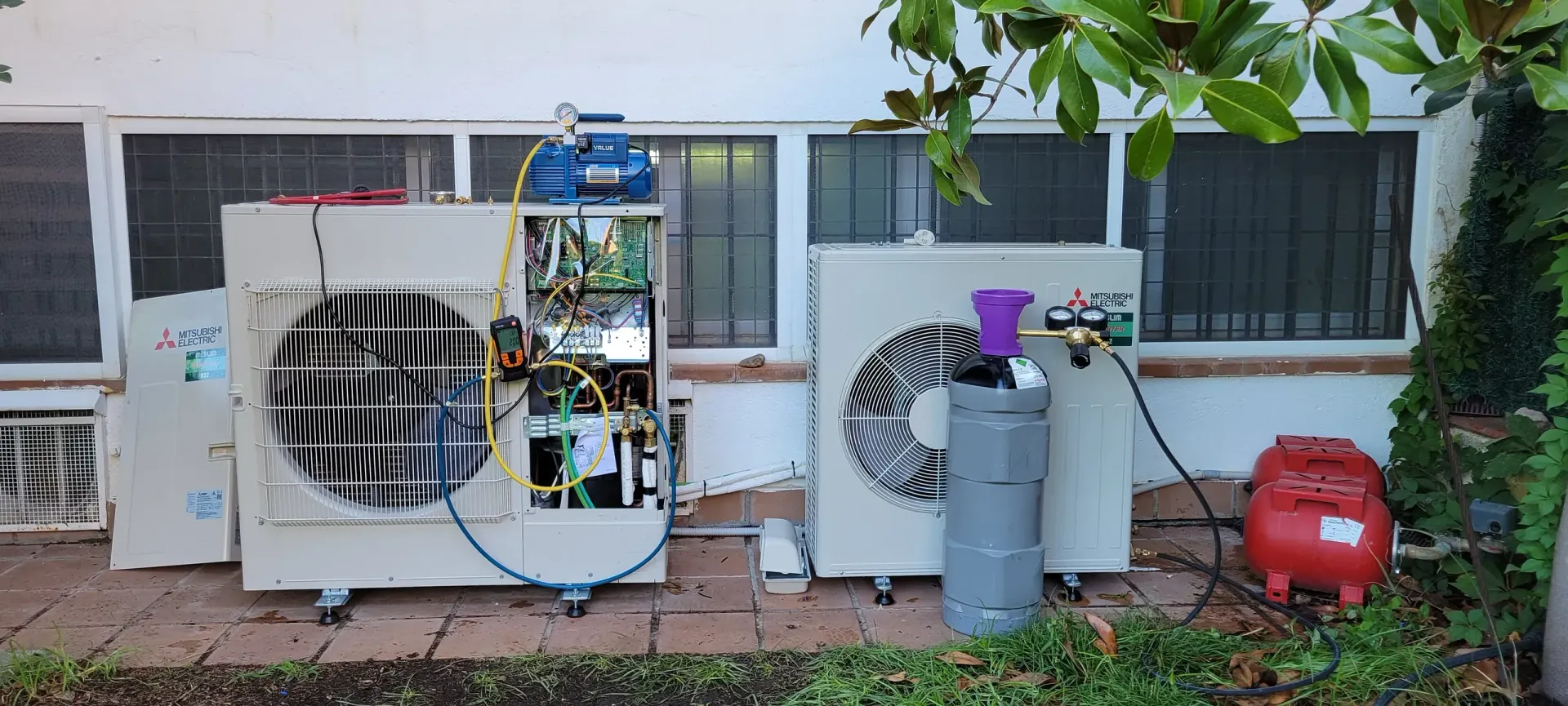 Un par de aparatos de aire acondicionado están afuera de un edificio.