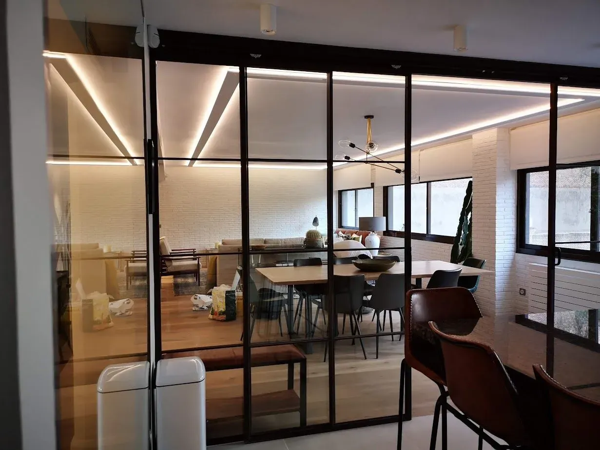 Una habitación con mesas y sillas y una puerta corrediza de vidrio.