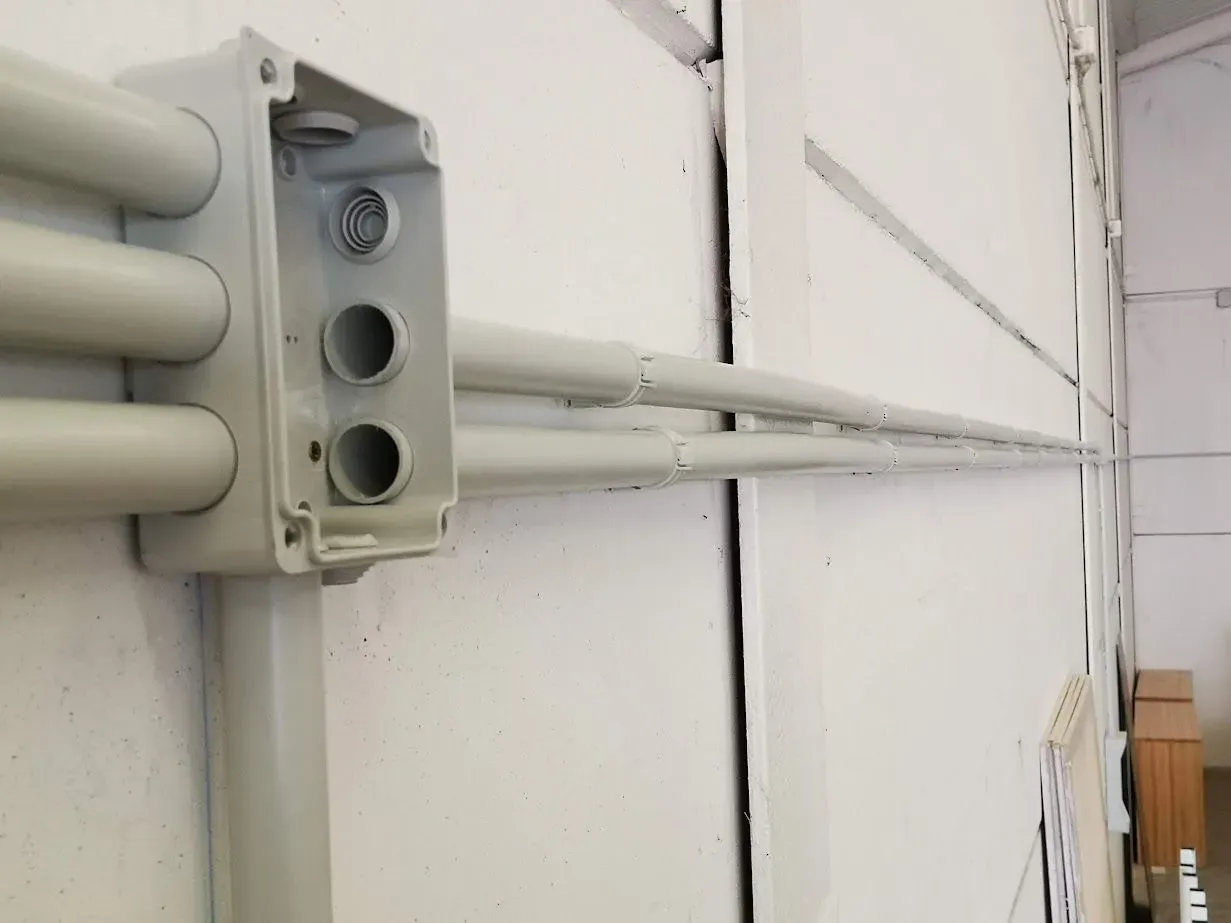 Un primer plano de una caja en una pared con cables eléctricos saliendo de ella.