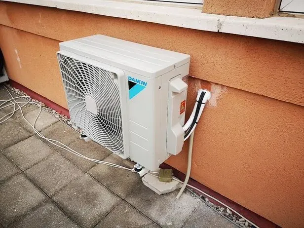Un acondicionador de aire Daikin está ubicado en el costado de un edificio.