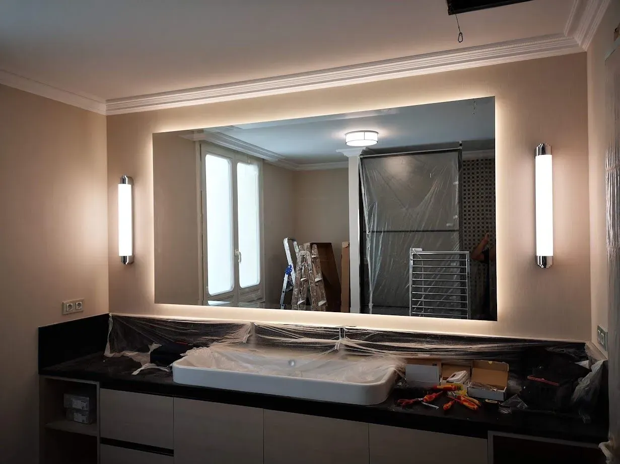 Un baño con un gran espejo y un lavabo.