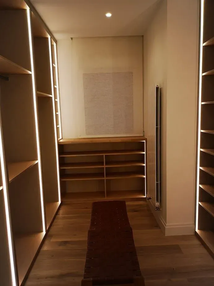 Un vestidor con muchos estantes y una alfombra.