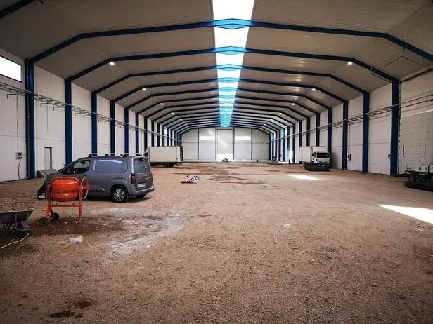 Un almacén vacío con una furgoneta aparcada en el medio