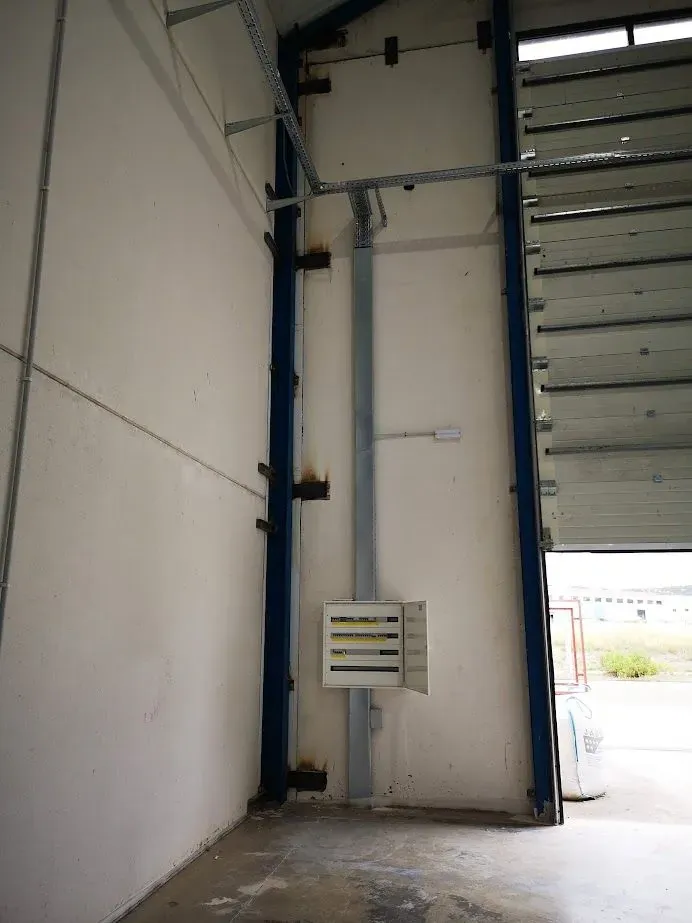 Un almacén vacío con una puerta azul y una pared blanca.