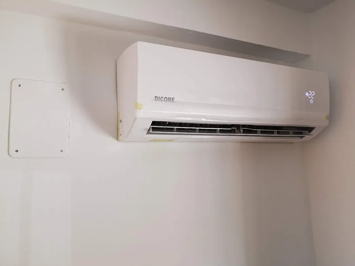 Un acondicionador de aire blanco está colgado en una pared blanca.