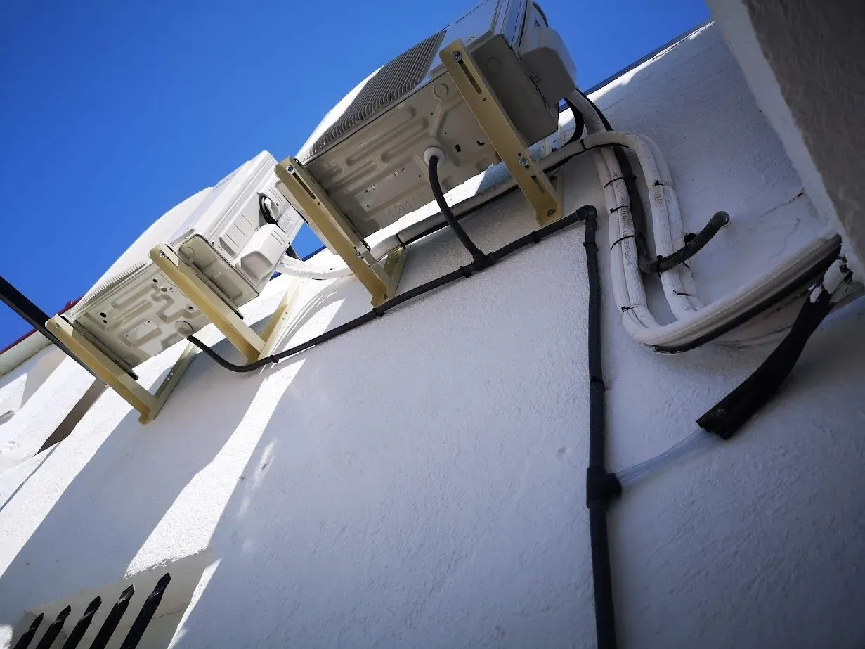 Una fila de aparatos de aire acondicionado están montados en el lateral de un edificio.