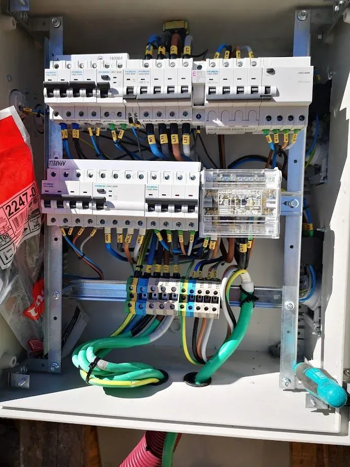 El interior de una caja eléctrica con muchos cables saliendo de ella.