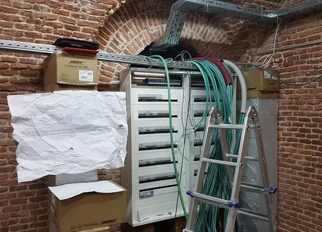 Una escalera está colocada delante de una pared de ladrillos.