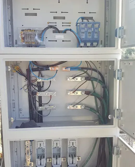 El interior de una caja eléctrica con muchos cables saliendo de ella.