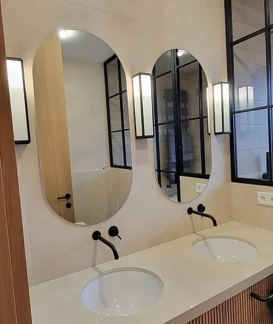 Un baño con dos lavabos y dos espejos