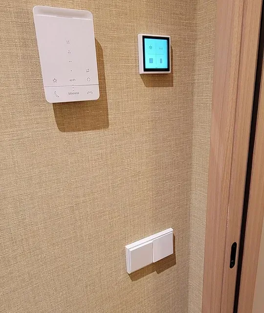 Hay un termostato en la pared al lado de una puerta.