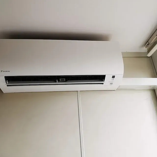 Un acondicionador de aire blanco cuelga del techo de una habitación.