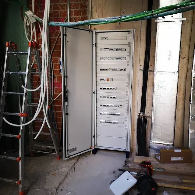 Una habitación con una escalera y un armario con la puerta abierta.