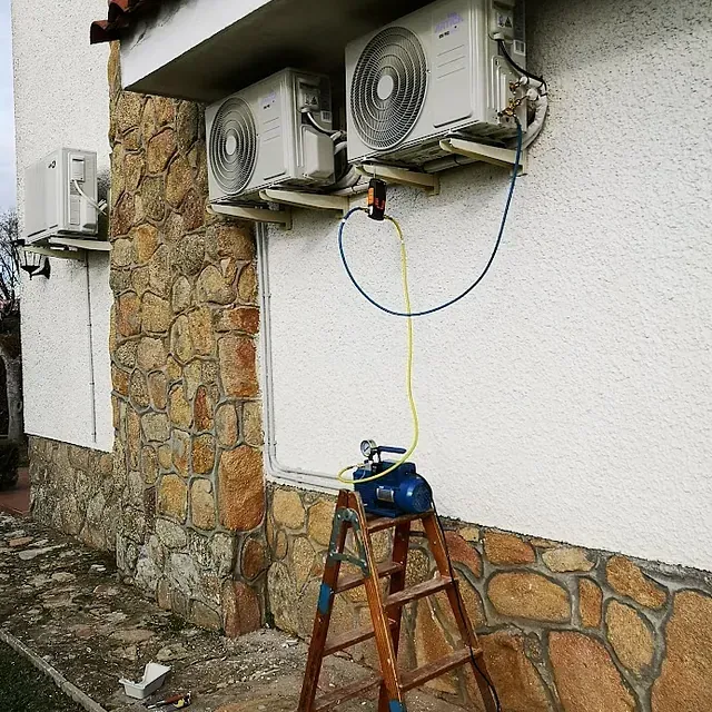 Tres acondicionadores de aire están montados en el lateral de un edificio.