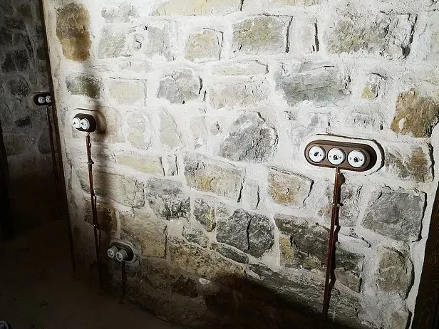Una pared de ladrillos con algunos enchufes eléctricos en ella.
