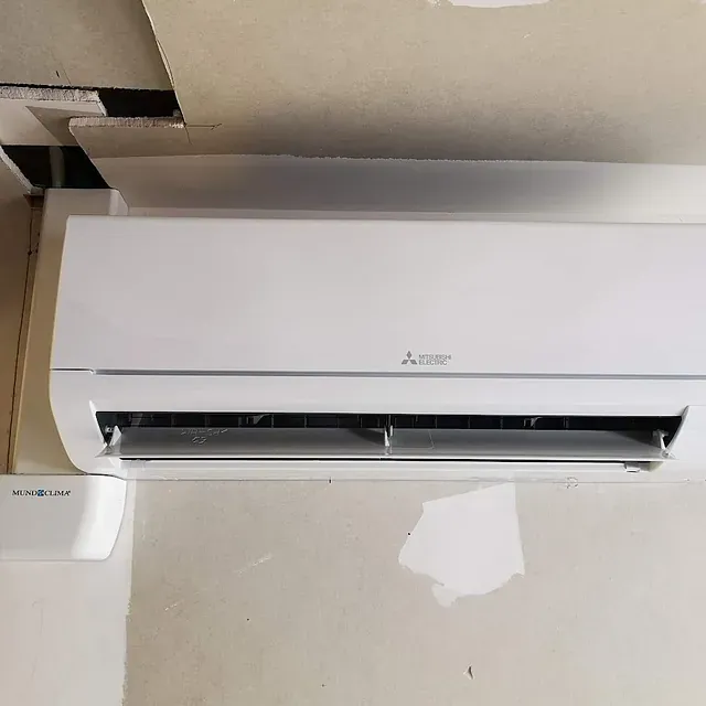 Un acondicionador de aire blanco está colgado en una pared.