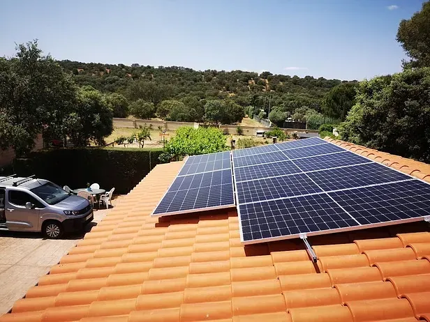 Una camioneta está estacionada en el techo de una casa con paneles solares.