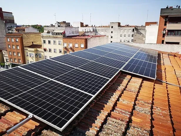 Hay muchos paneles solares en el tejado de un edificio.