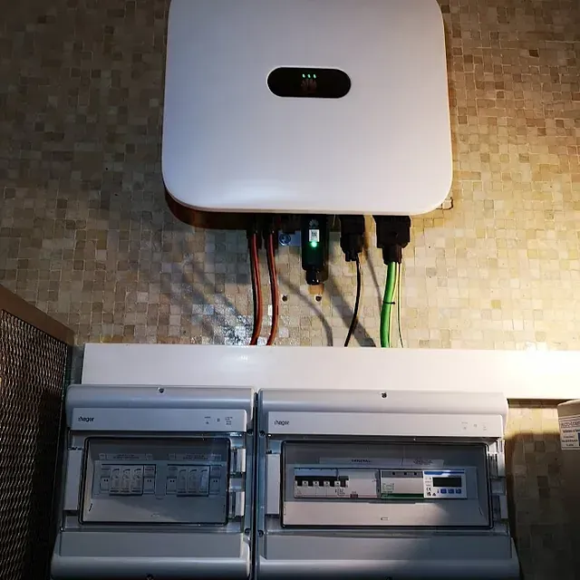 Una caja blanca está colocada encima de una pared al lado de una caja eléctrica.