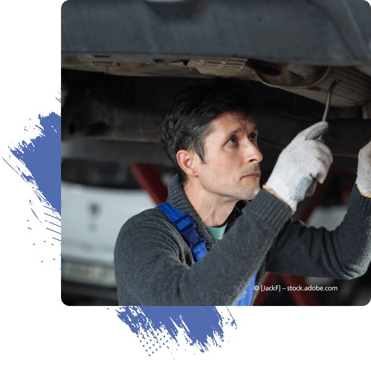 Ein Mann mit weißen Handschuhen arbeitet unter einem Auto