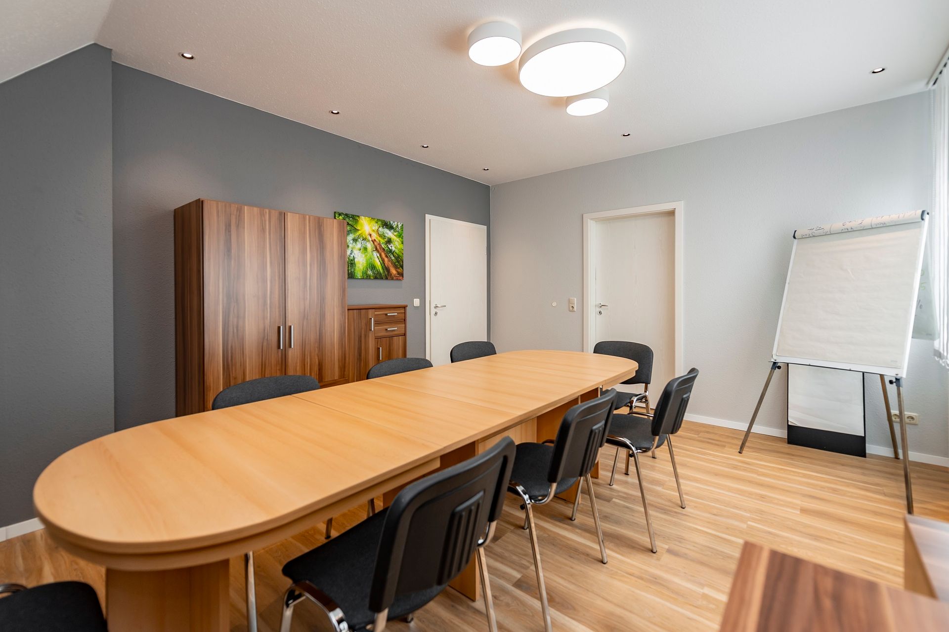 Ein Konferenzraum mit einem langen Holztisch und Stühlen.