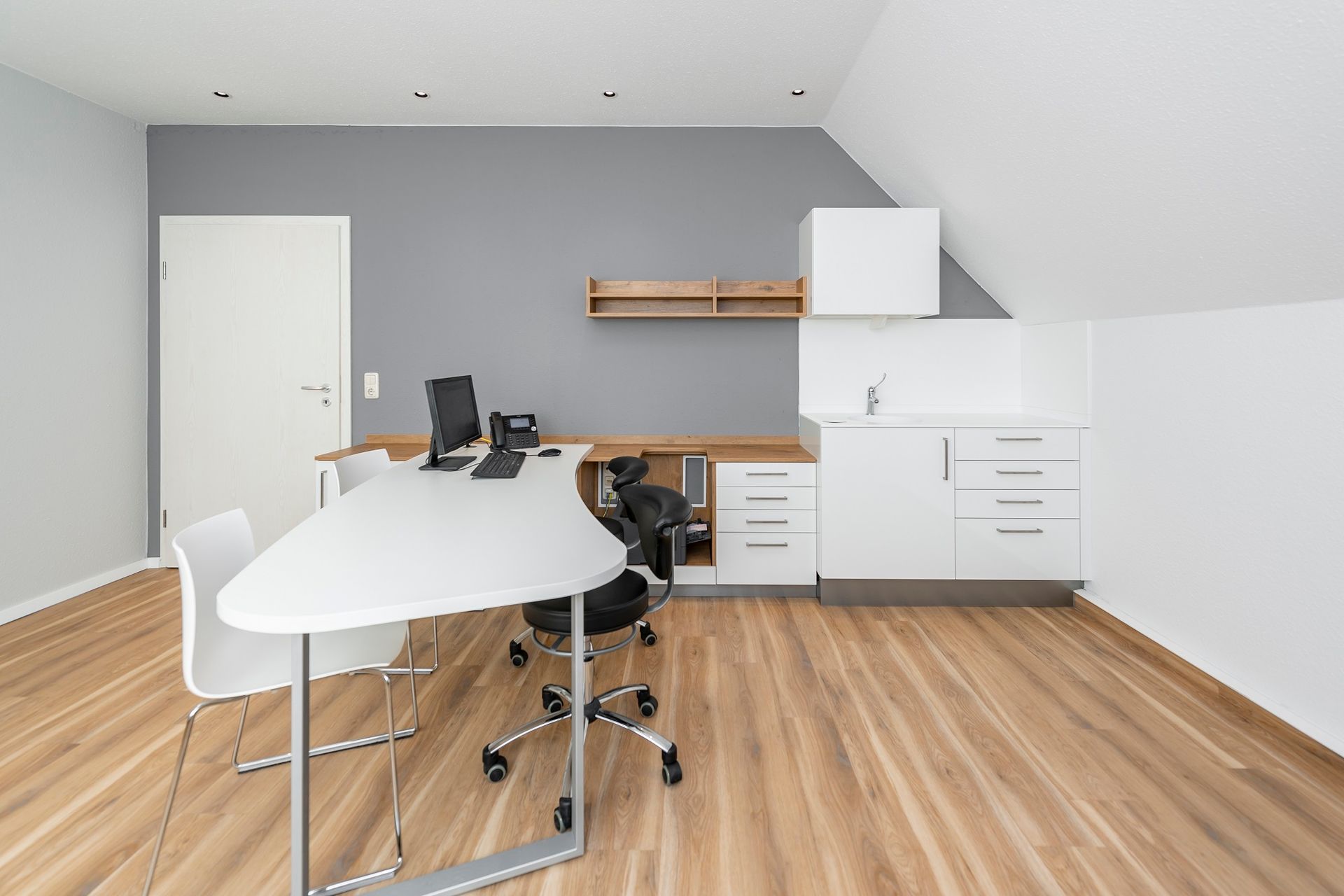 Ein Raum mit einem Tisch und Stühlen und einem Computer darauf.