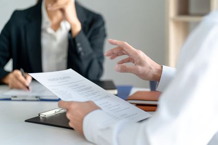 Deux personnes en train de parler à propos d'un document.